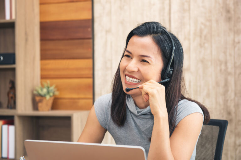 Call centre employees are smiling and working on laptop computer