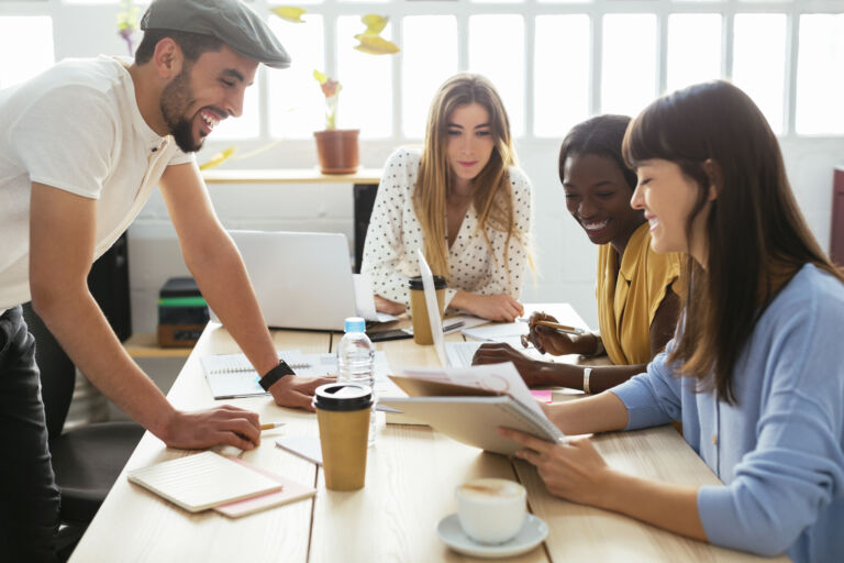 Smiling colleagues working together at desk in office